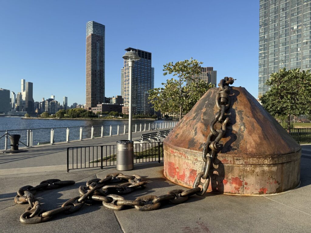 Photo of a large anchor connected to a 10-15 meters of heavy chain in a public park